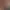 Une personne en tenue blanche prépare une table de massage dans une salle de spa en bois avec des fenêtres et des plantes