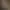 Une personne en tenue blanche et coiffe jaune prépare des plats dans des tajines posés sur un plateau métallique sur une table en bois en extérieur