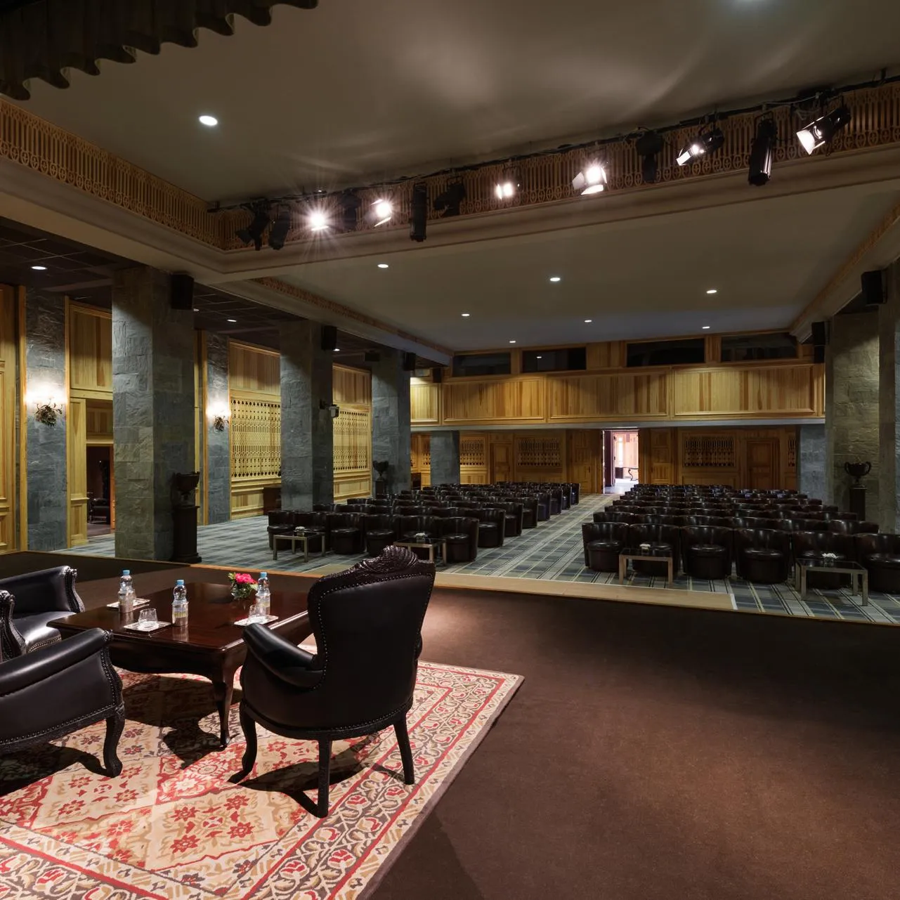 Conference room with rows of chairs and a lounge area with two armchairs and a coffee table