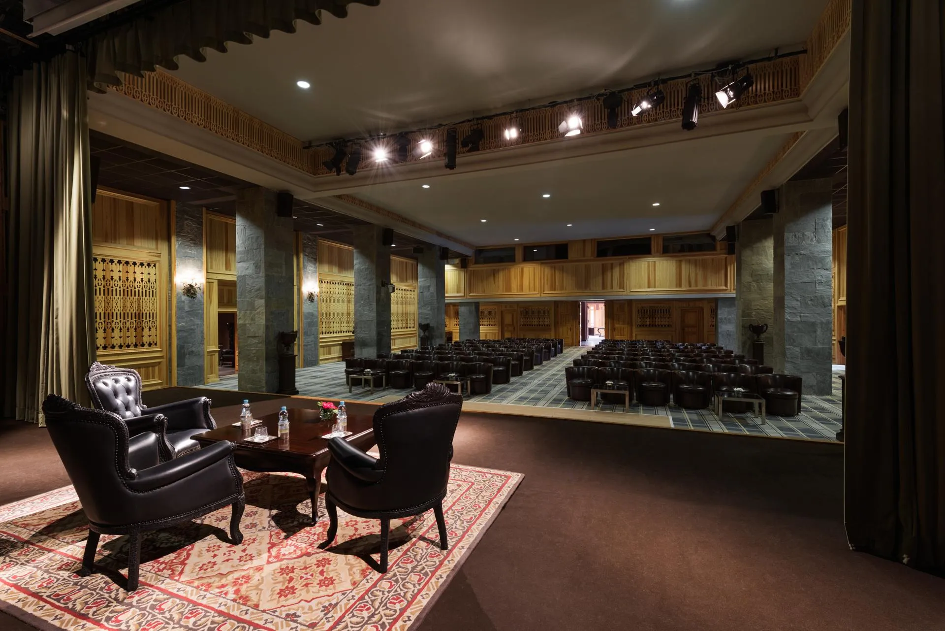 Conference room with rows of chairs and a lounge area with two armchairs and a coffee table