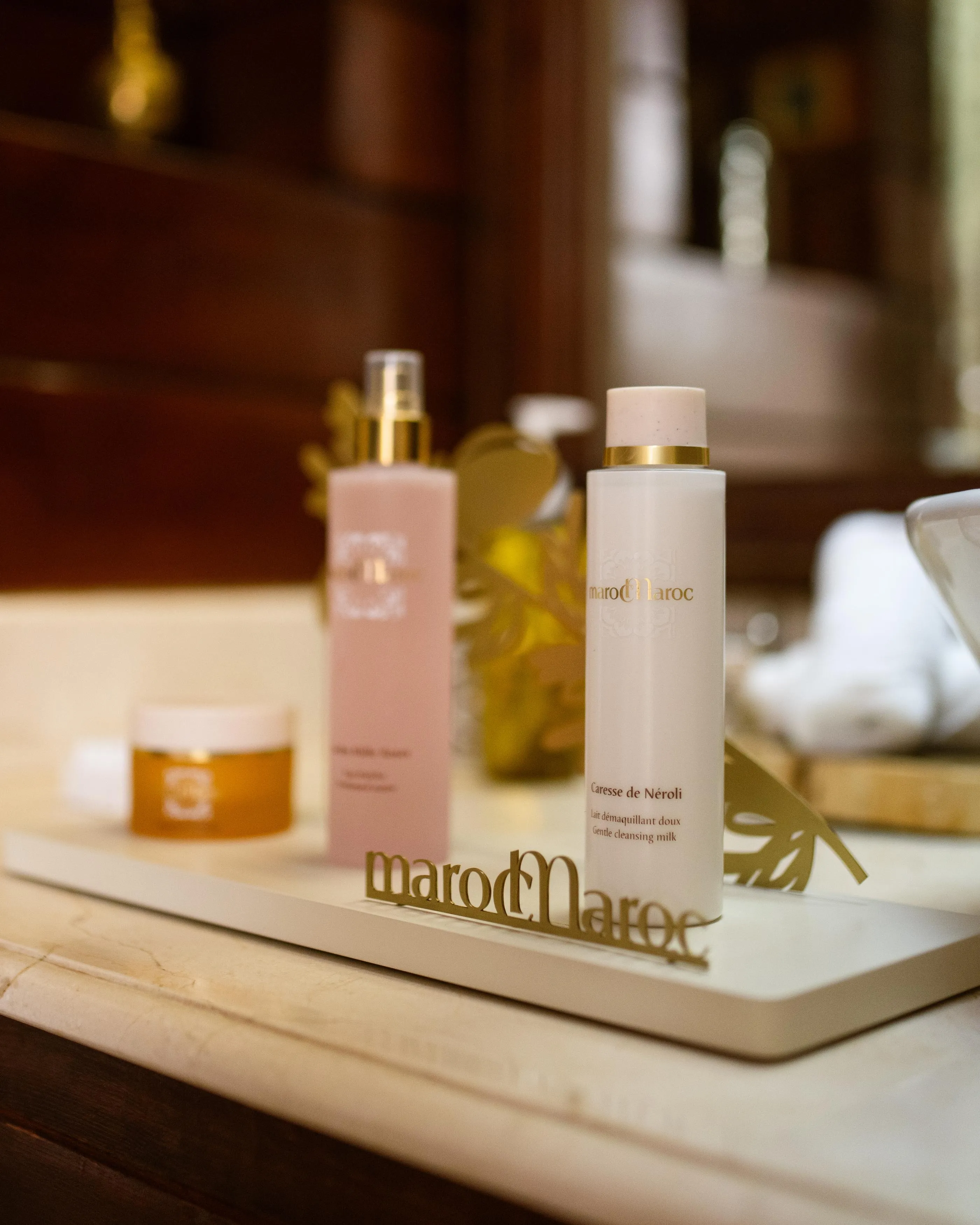 Two bottles of MarocMaroc brand cosmetics placed on a marble surface