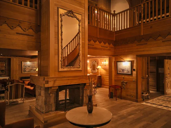 Wooden interior with staircase, fireplace and ornate mirror