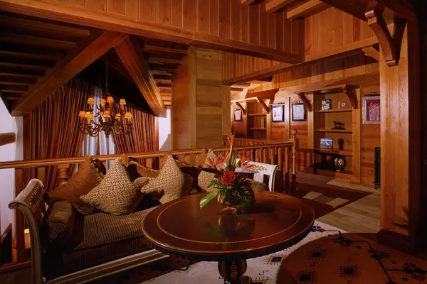 Wooden lounge with sofa, round table and hanging candelabras