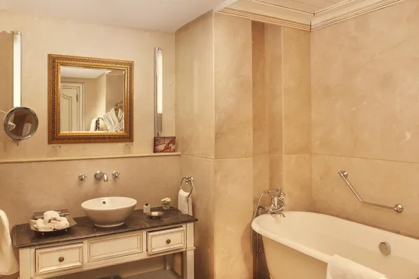 Bathroom with sink, framed mirror, bathtub and toiletries